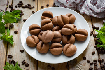 Chocolate chip cookies in the shape of coffee beans for dessert. Coffee cookies for breakfast. Close-up.