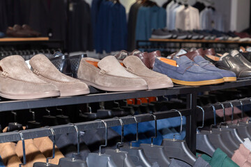 A rack of shoes in a store. There are several more pairs of shoes on the rack.