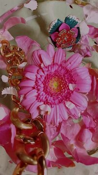 Gold chain in water with pink flowers