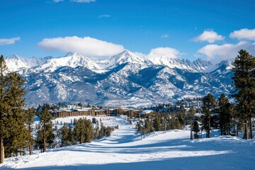Scenic winter mountain resort landscape, ski track in the foreground for travel ads