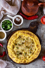An open potato pie for lunch. Potato pie on a gray background top view. vertical photo