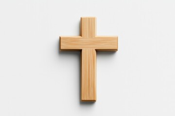 Simple wooden cross resting on a white surface, ideal for religious themes