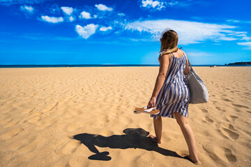 Mature woman tourist walking on beautiful sandy wide beach Meia Praia. Vacation in Lagos, Algarve,...