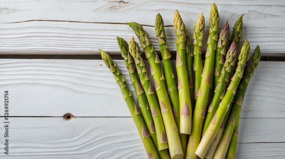 Poster fresh green asparagus spears arranged on white wooden background with natural light and copy space f