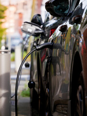 Fototapeta premium Electric and hybrid vehicles charging in city on parking charging station