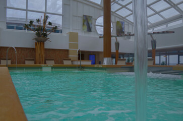 Indoor solarium swimmingpool with hot tub whirlpool inside thermal suite in spa or wellness area onboard luxury modern cruiseship or cruise ship liner for beauty and balance