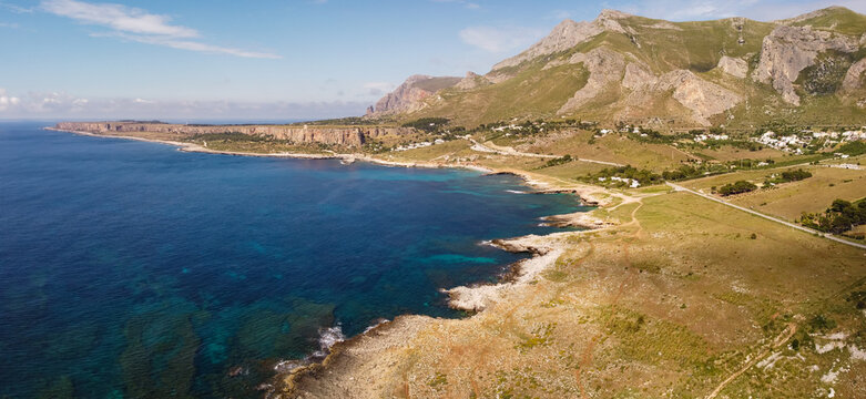 Aerial drone view of Macari (Makari), Sicily. Crystal clear turquoise waters, rugged cliffs, golden sandy beaches. A serene natural landscape with Mediterranean charm near San Vito lo Capo.