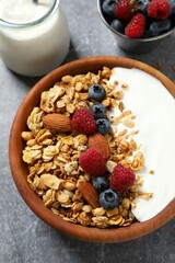 Delicious granola with berries and yogurt on a light background