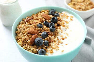 Delicious granola with berries and yogurt on a light background