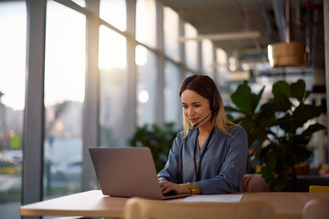 Smiling businesswoman having video call over laptop while working in office.