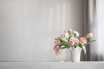 pink spring flowers in white ceramic vase on background whhite wall