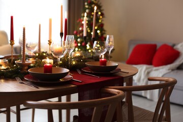 Festive table setting in room decorated for Christmas. Bokeh effect