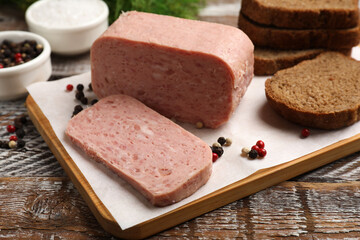 Canned meat, spices and bread on wooden table, closeup