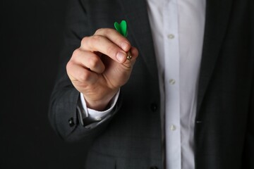 Man holding dart on black background, closeup