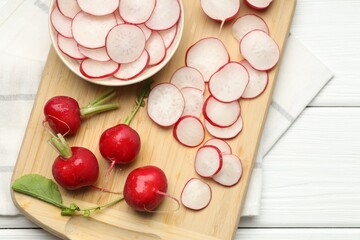 Fresh whole and cut radishes on white wooden table, top view