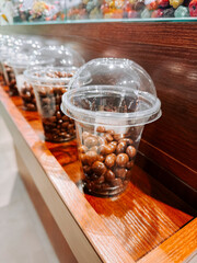 Clear containers filled with chocolate candies on wooden shelf in a confectionery store