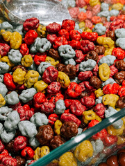 Colorful candy-coated popcorn mixture displayed in a glass bowl during an indoor event