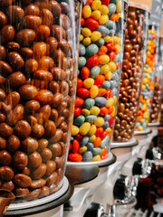 Colorful candy dispensers display a variety of sweets in a shop setting, inviting customers to explore different flavors and textures
