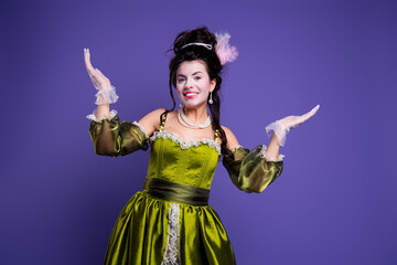 Portrait of a cheerful woman in elegant vintage attire with a green dress and purple background