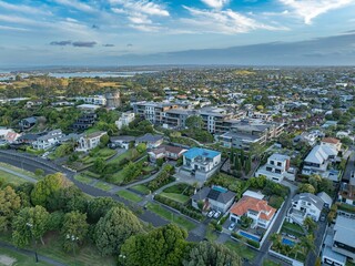 Fototapeta premium High-angle view of a residential neighborhood with modern and traditional homes. Variety of architectural styles, lush greenery, and streets. Urban landscape. GLENDOWIE, AUCKLAND, NZ