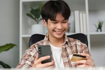 Excited young adult celebrating financial transaction with smartphone and credit card.