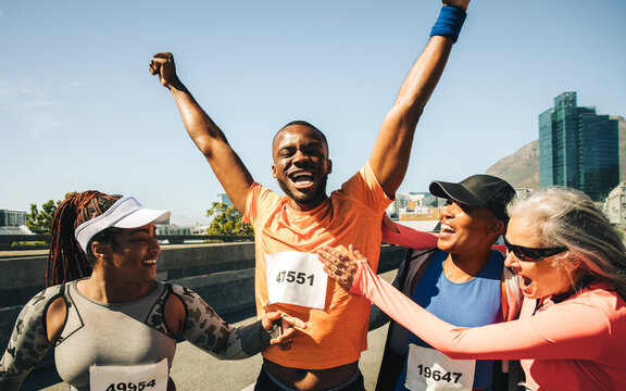 Joyful marathon runner celebrates victory with supportive friends