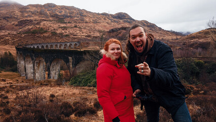 Tourists enjoying a snowy day near an iconic viaduct in Scotlands picturesque landscape