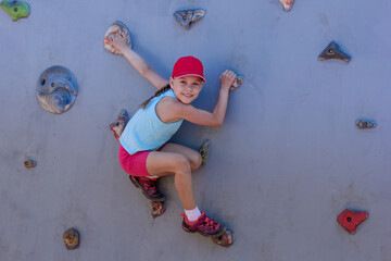 Happy child climbing on artificial rock wall on playground © Tatiana Foxy