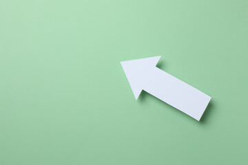 Paper arrow on color background, top view