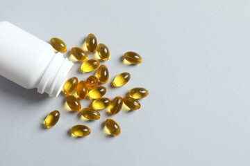 White bottle on a graybackground. Fish oil tablets. Biologically active additives. Omega 3, 6,...