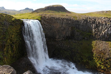 Iceland, wild nature in the land of fire and ice, flocks of sheep, horses and ponies in vast meadows, volcanoes surrounded by black lava fields, glaciers, ice floes floating in the ocean, skogafos