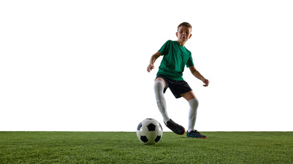 Obraz premium Dynamic image of focused boy, soccer player in green jersey and black short in motion, dribbling ball against white studio background. Concept of sport, education, competition, game