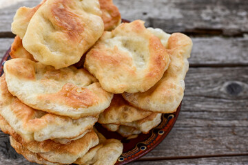 Traditional Bulgarian home made deep fried  patties  covered with sugar  оn rustic backgroud.Mekitsa or Mekica,  on wooden  rustic  background. Made of kneaded dough that is deep fried 