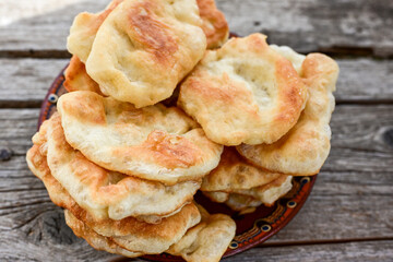 Traditional Bulgarian home made deep fried  patties  covered with sugar  оn rustic backgroud.Mekitsa or Mekica,  on wooden  rustic  background. Made of kneaded dough that is deep fried 