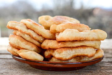 Traditional Bulgarian home made deep fried  patties  covered with sugar  оn rustic backgroud.Mekitsa or Mekica,  on wooden  rustic  background. Made of kneaded dough that is deep fried 