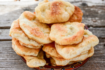 Traditional Bulgarian home made deep fried  patties  covered with sugar  оn rustic backgroud.Mekitsa or Mekica,  on wooden  rustic  background. Made of kneaded dough that is deep fried 