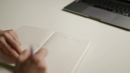 Hand Writing 'Day Plan' in Notebook with Numbered List