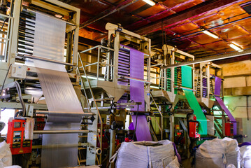 A roll of plastic film is being manufactured