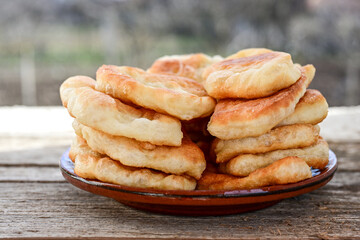Traditional Bulgarian home made deep fried  patties  covered with sugar  оn rustic backgroud.Mekitsa or Mekica,  on wooden  rustic  background. Made of kneaded dough that is deep fried 