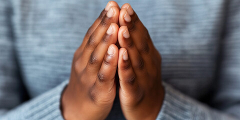Close-up of Clasped Hands Against Grey Fabric