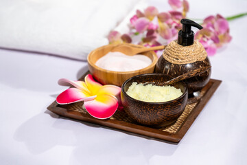 Spa therapy set with natural exfoliating scrub, essential oil, and floral decoration