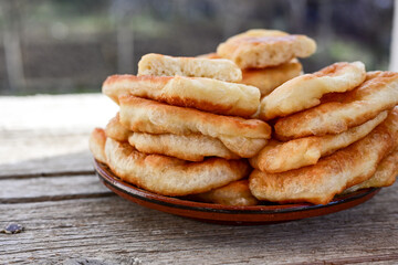 Traditional Bulgarian home made deep fried  patties  covered with sugar  оn rustic backgroud.Mekitsa or Mekica,  on wooden  rustic  background. Made of kneaded dough that is deep fried 