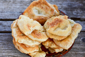 Traditional Bulgarian home made deep fried  patties  covered with sugar  оn rustic backgroud.Mekitsa or Mekica,  on wooden  rustic  background. Made of kneaded dough that is deep fried 