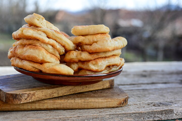 Traditional Bulgarian home made deep fried  patties  covered with sugar  оn rustic backgroud.Mekitsa or Mekica,  on wooden  rustic  background. Made of kneaded dough that is deep fried 
