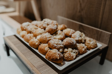 A delicious assortment of freshly baked sweet buns with a golden-brown crust, generously dusted with powdered sugar and crumble topping