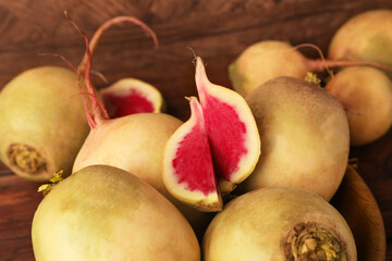 Whole and cut fresh turnips on table, closeup
