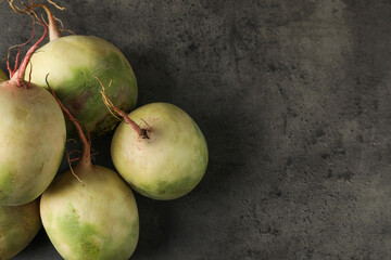Whole fresh ripe turnips on grey table, top view. Space for text