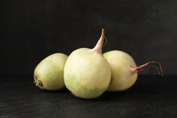 Whole fresh ripe turnips on black table