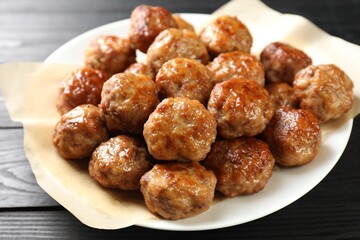 Many delicious meatballs on dark wooden table, closeup