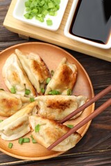 Eating fried gyoza dumplings at wooden table, top view